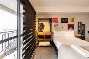 une chambre avec un lit et une grande fenêtre dans l'établissement B Homy Genebra, à São Paulo