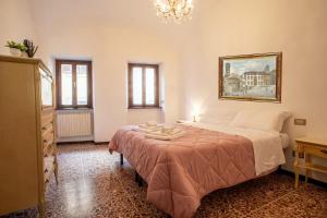 a bedroom with a bed and a chandelier at Piazza Grande-Giallo Cremisi in Arezzo
