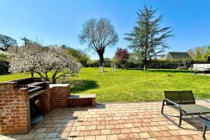 a bench sitting on a brick patio with a park at Le Gîte d’en Bas-St Valery à 15min-Équipement bébé in Quesnoy-le-Montant