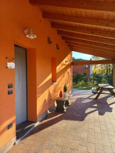 an orange building with a bench and a table at Room & Breakfast Olmo Tondo in San Giovanni in Persiceto