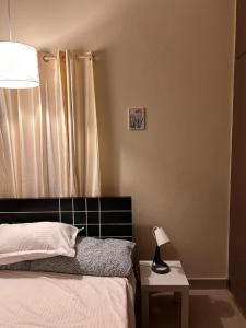 a bedroom with a bed and a lamp on a table at Electrifying 2BHK Gateways in Bengaluru
