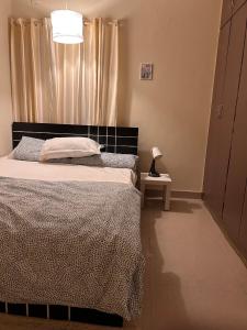 a bedroom with a bed and a lamp on a table at Electrifying 2BHK Gateways in Bengaluru