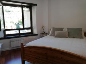 a bedroom with a large bed and two windows at Esterri Confort in Esterri d'Àneu