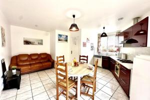 cocina y comedor con mesa y sofá en Le Fleuri-Plain-pied-St Valery & Le Crotoy à 10min, en Noyelles-sur-Mer