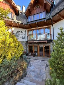 a building with a patio and a balcony at Pensjonat Sekuła*** in Bukowina Tatrzańska