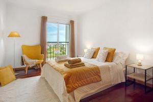 a bedroom with a large bed and a window at Casa Nóbrega in Caniço
