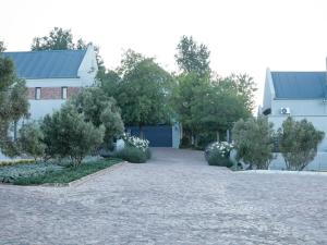 a driveway leading to a house with a blue garage at Gilgal Guest Accommodation in Onder-Papegaaiberg