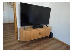 a flat screen tv sitting on top of a wooden stand at Haus Kerkyra in Dickesbach