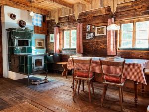 a dining room with a table with chairs and a stove at Turracher Hütte in Turracher Hohe +16 photos