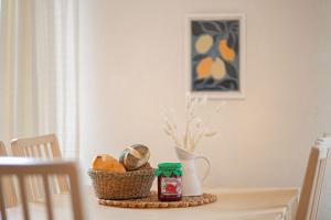 Una mesa con una cesta de pan y un tarro de mermelada. en Ferienwohnung 1, en Todendorf auf Fehmarn