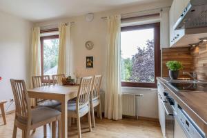 Una cocina y un comedor con mesa y sillas. en Ferienwohnung 1, en Todendorf auf Fehmarn