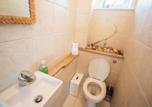 une petite salle de bain avec toilettes et lavabo dans l'établissement Pebbles Beach House By Air Premier, à Seaford 9 autres photos
