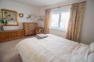 une chambre avec un lit, une commode et une fenêtre dans l'établissement Pebbles Beach House By Air Premier, à Seaford