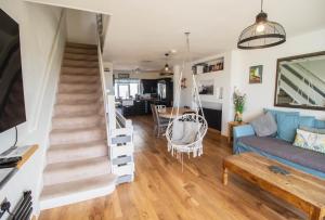un salon avec un escalier et un canapé dans l'établissement Pebbles Beach House By Air Premier, à Seaford