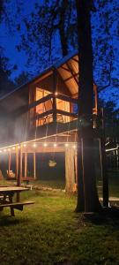 a house with a tree in front of it at Tree House Glamping Destination near the Ozarks, with River Access for Swimming and Fishing in West Liberty +9 photos