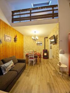 a living room with a couch and a table at ALLA CASCATA in centro Branzi self check-in parcheggio gratuito coperto in Branzi