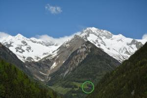 a mountain with a green circle in front of it at Jägerhütte in Lutago