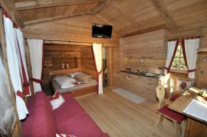 a bedroom in a log cabin with a bed and a desk at Jägerhütte in Lutago