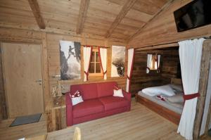 a living room with a red couch in a cabin at Jägerhütte in Lutago