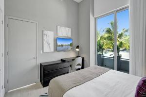 een slaapkamer met een bed, een bureau en een raam bij Amazing Apartments At H Beach House in Hollywood +187 foto's