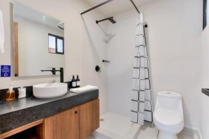 een badkamer met een toilet, een wastafel en een douche bij Great location depto with Gym in Cancun +26 foto's