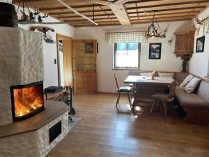 a living room with a fireplace and a table at Hochsteinalm in Vichtau