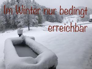 a snow covered yard with a sign that reads in winter n winter beaterater at Hochsteinalm in Vichtau