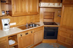 a kitchen with wooden cabinets and a sink at Hoamatlhütte in Schladming
