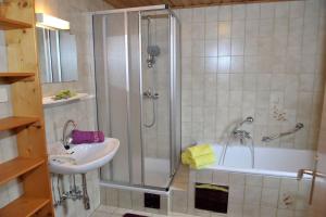 a bathroom with a shower and a sink and a tub at Hoamatlhütte in Schladming