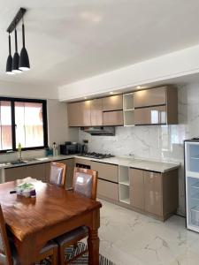 cocina grande con mesa de madera, mesa y sillas en Favorite Staycation by Janice - Modern Comfort Near Airport, en Nairobi