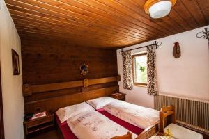 a bedroom with a bed in a room with a wooden ceiling at Hinterauhof in Rain +1 photo