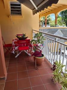 einen Balkon mit einem Tisch und Pflanzen darauf in der Unterkunft Maison accueillante à Sainte-Rose, 25 m² et balcon in Duzer
