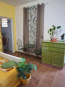 ein Wohnzimmer mit einem grünen Schrank und einem Tisch in der Unterkunft Maison accueillante à Sainte-Rose, 25 m² et balcon in Duzer + 10 Fotos