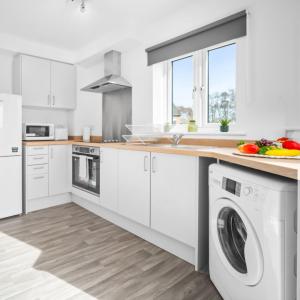 a kitchen with white cabinets and a washer and dryer at Two Bedrooms Apartment - Parking - Cradley Heath 51C in Netherton