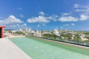 een zwembad op het dak van een gebouw bij Great location depto with Gym in Cancun