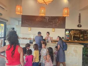 a group of people standing around a counter in a restaurant at Sitar Ramon in Mitzpe Ramon