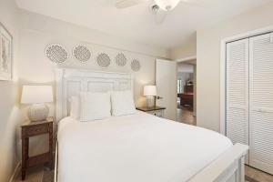 a bedroom with a white bed and two lamps at CA411: 411 Carolina Blvd. in Isle of Palms +28 photos