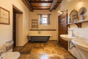 a bathroom with two sinks and a tub and a toilet at Count Kálnoky's Transylvanian Guesthouses in Micloşoara +98 photos