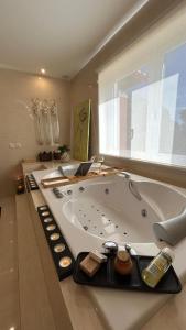 a bath tub in a bathroom with a large window at Monte d'Alto in Santo Estêvão