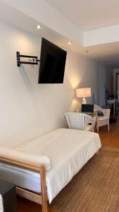 a room with a bed with a flat screen tv on the wall at Monte d'Alto in Santo Estêvão