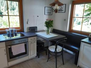 a kitchen with a table and a stove top oven at Jägerkeusche in Unterpreitenegg