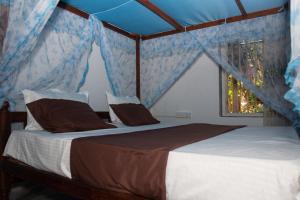 1 dormitorio con 1 cama grande y techo azul en VN45 Villa in Ahangama, en Ahangama