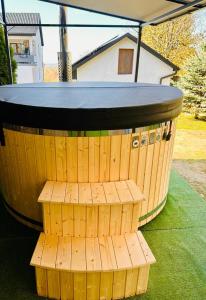 a wooden barrel with a table on the grass at Apartament Sweet Garden in Huta Szklana +4 photos