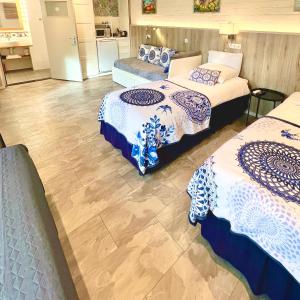 een hotelkamer met 3 bedden en een keuken bij Rooi Bij de Knoptoren B&B in Sint-Oedenrode