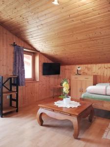 a room with a bed and a table and a tv at Chalet Luxeck in Steinberg am Rofan