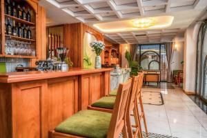 Misaki HCM Airport Hotel في مدينة هوشي منه: بار في مطعم بمقاعد خضراء