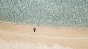 een persoon op een strand naast de oceaan bij Hotel Aquadulci in Chia