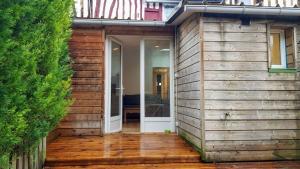 ein Haus mit Holzfassade und einer Tür in der Unterkunft Le FleuryTerre - Grand 2 pièces avec terrasse in Déville-lès-Rouen
