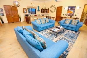 a living room with blue couches and a table at Emerald Sunset Villa in Zanzibar City