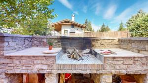 a stone wall with a fire pit in front of a house at Casa Las Tinajas in Alcalá de la Selva